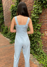 Load image into Gallery viewer, Arrive the most adorable jumpsuit ever when you walk in wearing this beautiful blue jumpsuit. This classy jumpsuit features scallop edges on the straps and along the top of the bodice. It has tabs with buttons for added style on the shoulders and waistline. Zip up back closure. Long tapered legs.    61% polyester, 37% cotton, and 2% spandex  Available in sizes x-small, small, medium, and large Zip back closure
